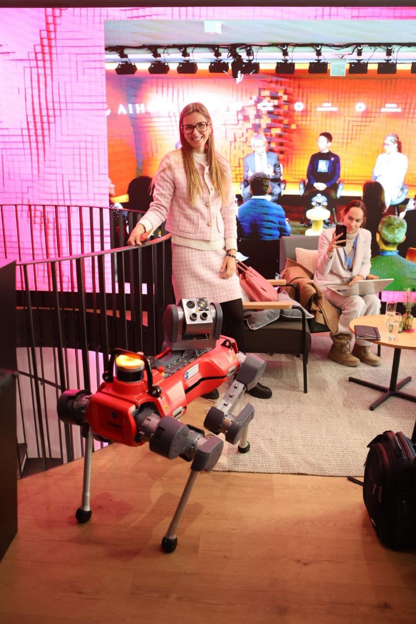 Kateryna Portmann with a quadruped robot on stage at AI House Davos