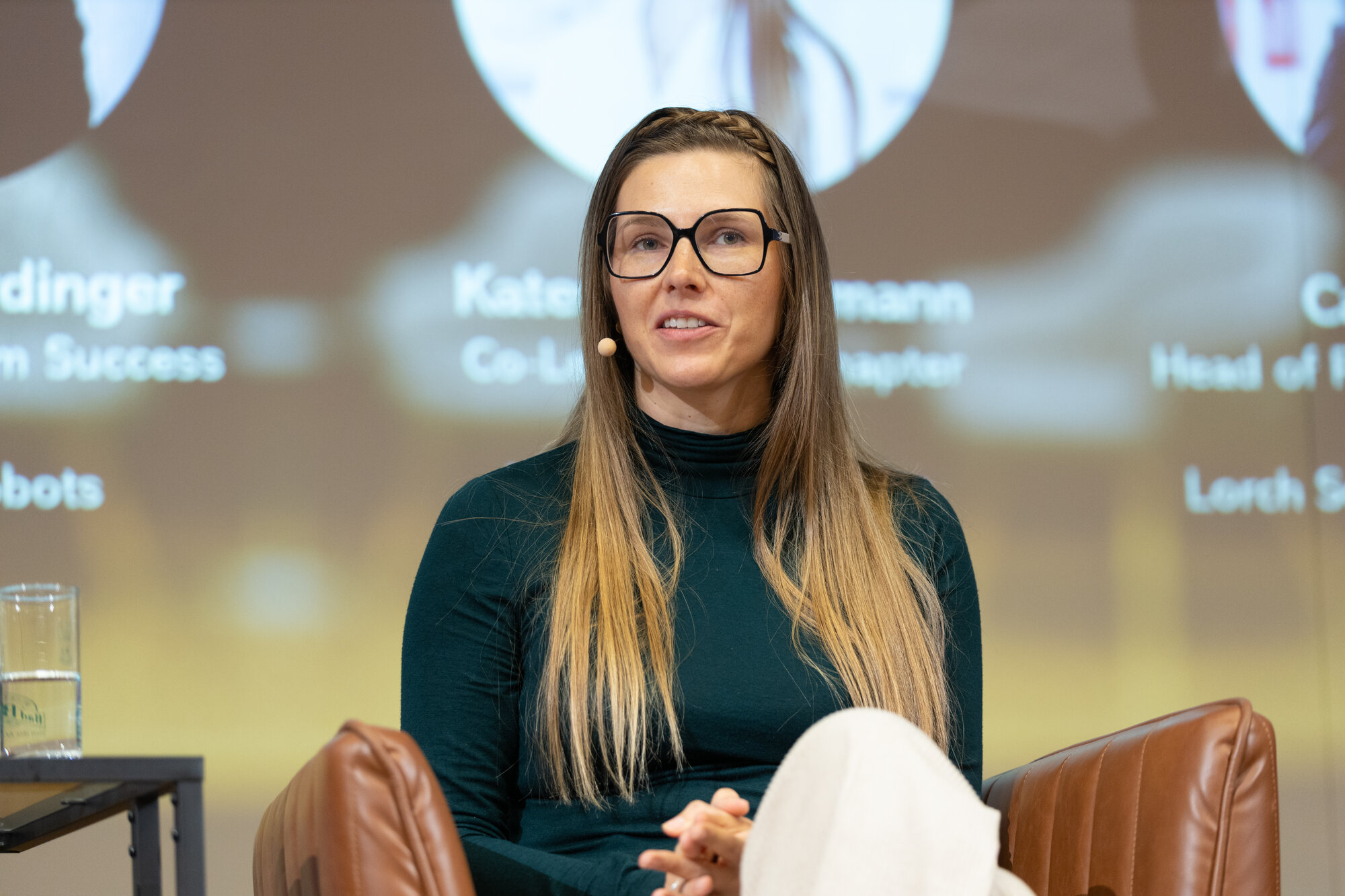 Close-up of Kateryna Portmann speaking with a lavalier microphone at a robotics conference panel
